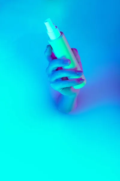 Közelkép női kézfogás kozmetikai befőttesüveg jelenik meg a tejfürdő lágy fehér ragyogás neon fény. Beaty, kozmetikumok, divat, művészet — Stock Fotó