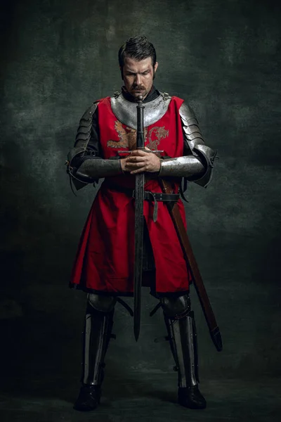 暗い背景に孤立剣を保持汚れた負傷顔を持つ残酷なシリアル男、中世の戦士や騎士の肖像画。時代の比較 — ストック写真