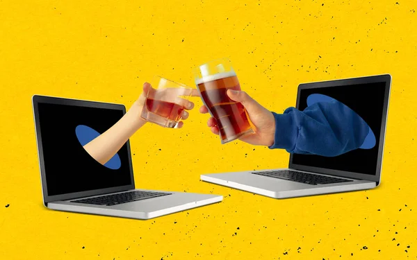 Två händer sticker ut bärbar skärm och klinkande öl och whisky glas varandra isolerade över gul bakgrund. — Stockfoto