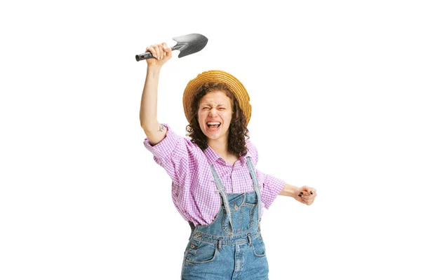 Eccitato giovane ragazza, giardiniere in uniforme da lavoro e cappello posa isolata su sfondo bianco. Concetto di lavoro, emozioni, agronomia, eco — Foto Stock