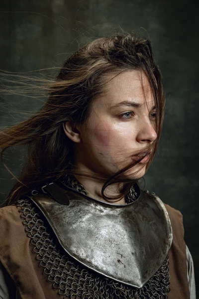 Close-up vintage retrato de mulher adorável, guerreira medieval ou cavaleiro com rosto sujo ferido olhando para longe isolado sobre fundo retro escuro. — Fotografia de Stock
