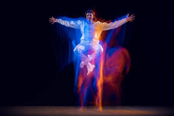 男性嘻哈舞蹈演员的动态肖像，在混合的霓虹灯下，在黑暗的背景下孤立地跳舞。青年文化、嘻哈、运动、风格和时尚、行动. — 图库照片