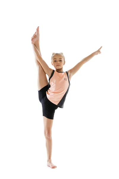 Little flexible girl, rhythmic gymnastics artist isolated on white studio background. Grace in motion, action. Doing exercises in flexibility. — Stock Photo, Image