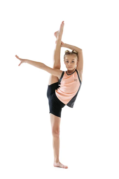 Kleines flexibles Mädchen, rhythmische Turnerin isoliert auf weißem Studiohintergrund. Gnade in Bewegung, Aktion. Übungen in der Beweglichkeit. — Stockfoto