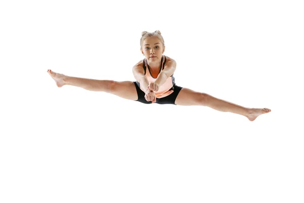 Little flexible girl, rhythmic gymnastics artist jumping isolated on white studio background. Grace in motion, action. Doing exercises in flexibility. — Stock Photo, Image