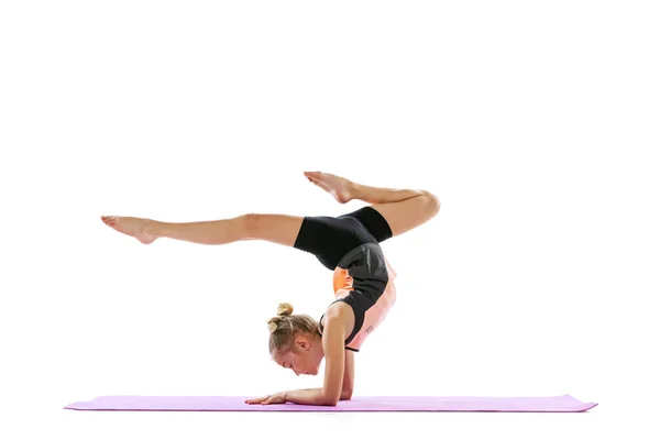 One flexible young girl, rhythmic gymnastics artist practicing isolated on white studio background. Grace in motion, action. Doing exercises in flexibility. — Stock Photo, Image