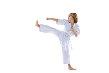 Bir sportif küçük oğlan çocuğu, tekvando sporcuları, beyaz arka planda yalnız başına antrenman yapan doboklar giyiyorlar. Spor anlayışı, dövüş sanatları