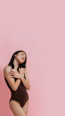 Pembe stüdyo arkaplanından izole edilmiş güzel bir kadının portresi.