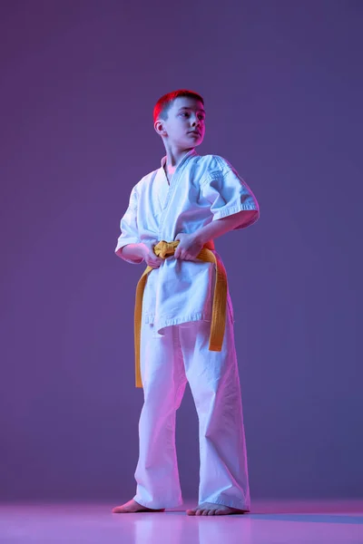 Komoly gyerek, kisfiú, taekwondo vagy karate sportolók doboks pózol elszigetelt nagyon peri színű háttér neon. A sport, a harcművészetek fogalma — Stock Fotó