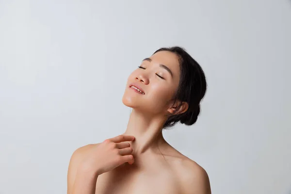 Recortado estudio retrato de tierna mujer asiática posando aislado sobre gris fondo — Foto de Stock