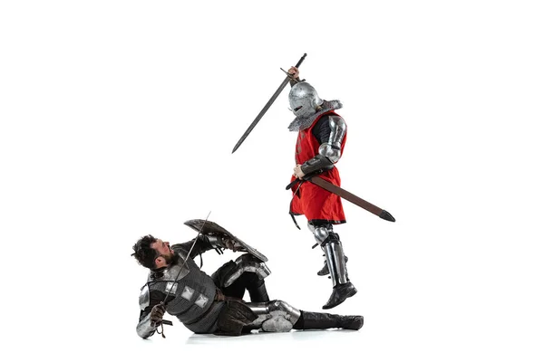Retrato de dois homens lutando, guerreiro medieval atacando com espada outro cavaleiro isolado sobre fundo estúdio branco — Fotografia de Stock