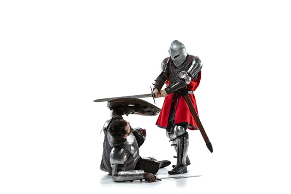 Full-length portrait of two medieval warriors, knights fighting isolated over white studio background — Stock Photo, Image