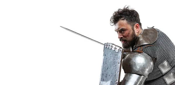 Φλάιερ με θάρρος μεσαιωνικός πολεμιστής, ιππότης με ειδική πανοπλία προστατεύοντας τον εαυτό του με ασπίδα και σπαθί απομονωμένος πάνω από λευκό φόντο στούντιο — Φωτογραφία Αρχείου