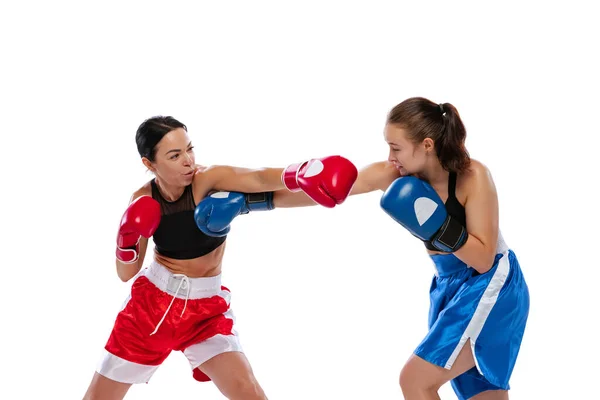 Dos boxeadoras profesionales de boxeo aisladas sobre fondo de estudio blanco. Un par de atletas caucásicos musculosos en forma peleando. Deporte, competición — Foto de Stock