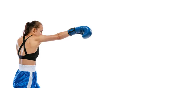 Vista de perfil de una joven deportista, boxeadora profesional practicando en guantes de boxeo aislados sobre fondo blanco del estudio. Concepto de deporte, estudio, competición — Foto de Stock