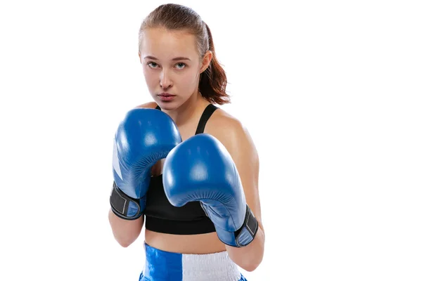 Vue de la caméra avant de la jeune fille, boxeuse professionnelle pratiquant en uniforme de sport et gants de boxe isolés sur fond de studio blanc. Concept de sport, d'étude, de compétition — Photo