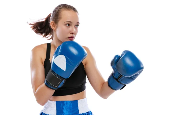 En action, motion. Jeune fille, boxeuse professionnelle pratiquant dans des gants de boxe isolés sur fond de studio blanc. Concept de sport, d'étude, de compétition — Photo
