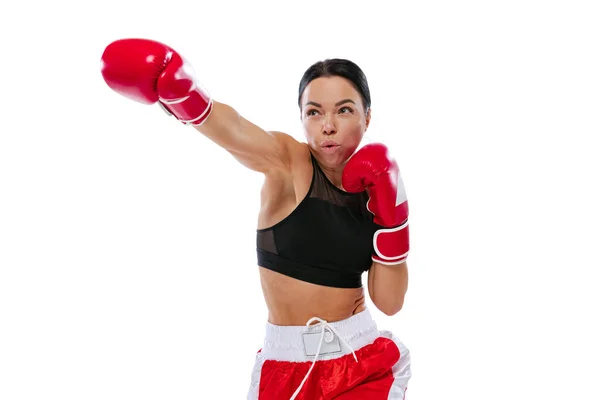 En acción, movimiento. Jovencita, boxeadora profesional practicando con guantes de boxeo aislados sobre fondo blanco de estudio. Concepto de deporte, estudio, competición — Foto de Stock