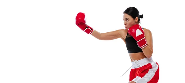 W akcji, ruch. Młoda dziewczyna, zawodowy bokser ćwiczący w rękawiczkach bokserskich odizolowanych na białym tle studia. Koncepcja sportu, nauki, rywalizacji — Zdjęcie stockowe