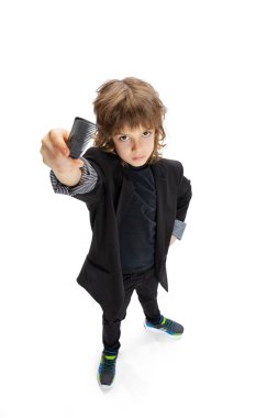 Küçük bir çocuğun portresi, şık bir kuaför imajı olan bir çocuk, beyaz stüdyo arka planında izole edilmiş berber. Meslek kavramı, modern uzmanlar, çocukluk.