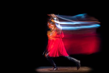 Ateş, enerji. Acımasız ciddi bir adamın portresi, Ortaçağ şövalyesi ya da zırhlı ve zırhlı bir savaşçı neon ışıklı karanlık bir arka plana karşı savaşıyor. Sanat, tarih, yaratıcılık