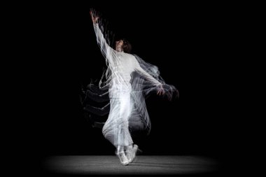 Genç bir adam, hip-hop dansçısı, karanlık arka planda sroboskop etkisi ile izole edilmiş hareket ediyor. Gençlik kültürü, hip-hop, hareket, tarz ve moda, aksiyon.