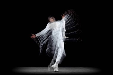 Genç bir adam, hip-hop dansçısı, karanlık arka planda sroboskop etkisi ile izole edilmiş hareket ediyor. Gençlik kültürü, hip-hop, hareket, tarz ve moda, aksiyon.