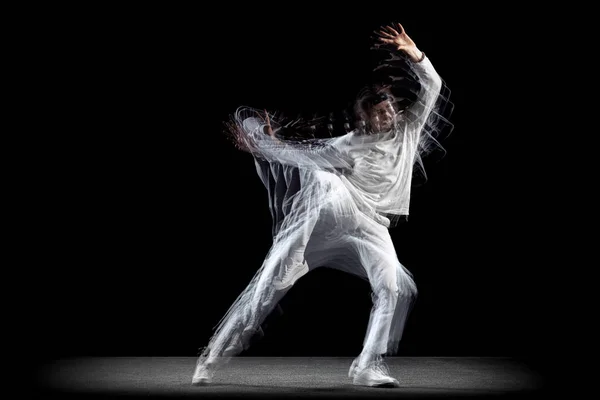 Mladý muž, hip-hopový tanečník v akci, pohyb izolovaný na tmavém pozadí se sroboskopickým efektem. Mládež kultura, hip-hop, pohyb, styl a móda, akce. — Stock fotografie