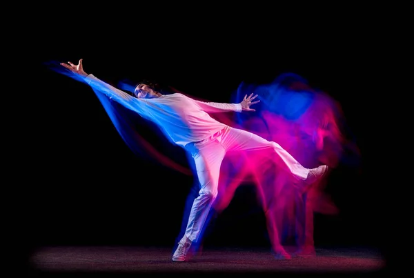 男性嘻哈舞蹈演员的动态肖像，在混合的霓虹灯下，在黑暗的背景下孤立地跳舞。青年文化、嘻哈、运动、风格和时尚、行动. — 图库照片