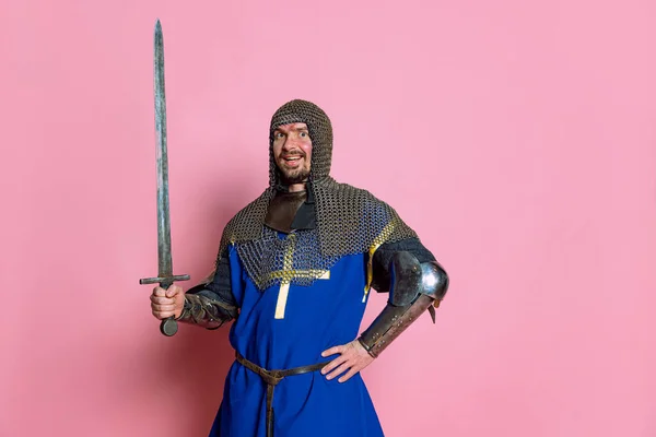 Retrato de meio-comprimento do homem, guerreiro medieval ou cavaleiro com rosto ferido posando isolado sobre fundo de estúdio rosa — Fotografia de Stock