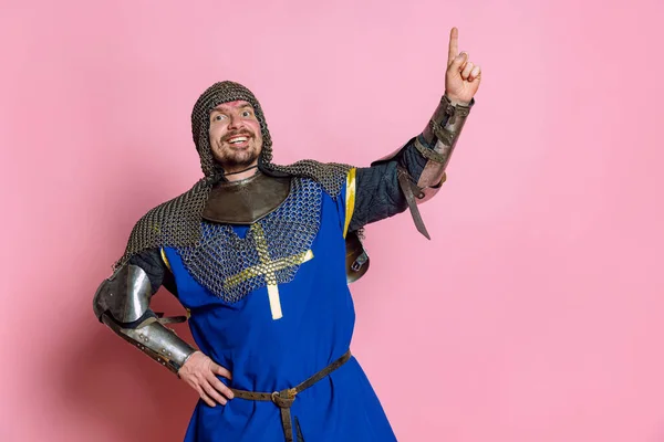 Porrait de homem animado, guerreiro medieval ou cavaleiro em proteção crescente dedo expressando ideia isolada sobre fundo de estúdio rosa — Fotografia de Stock
