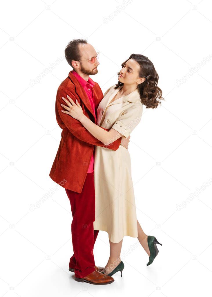 Young married couple, young man and woman in old-school fashioned attire hugging isolated on white background. Vintage, hipster