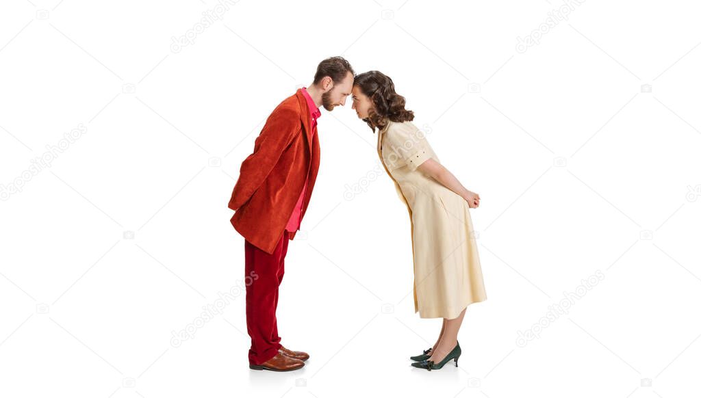 Two people, young man and woman in old-school fashioned attire standing with foreheads touching isolated on white background. Vintage concept