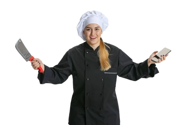 Mujer joven emocionada, cocinera, chef en uniforme negro aislado sobre fondo blanco. Cocina, profesión, negocio, comida, gusto, concepto de restaurante. —  Fotos de Stock