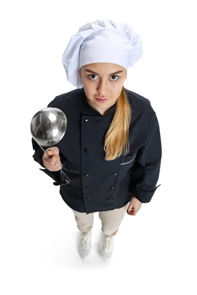 Vue grand angle de belle jeune femme, dame cuisinière, chef en uniforme noir isolé sur fond blanc. Cuisine, profession, entreprise, nourriture, goût, concept de restaurant. — Photo