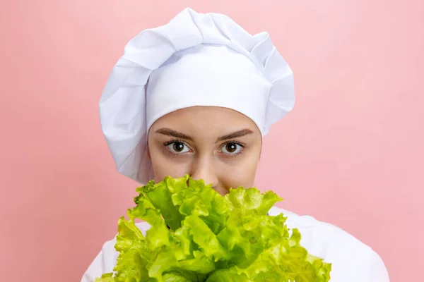 Jeune femme, dame cuisinière, chef en uniforme blanc posant isolée sur fond rose. Cuisine, profession, entreprise, nourriture, goût, concept de restaurant. — Photo