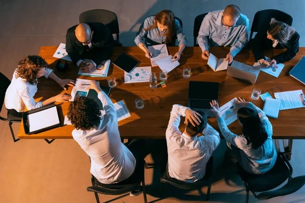 Vista aérea de jóvenes multiétnicos hablando, trabajando con colegas, compañeros de trabajo en la oficina, en interiores. Trabajo, finanzas, concepto tecnológico. — Foto de Stock
