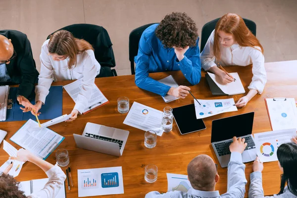 Formazione di nuovi dipendenti. Veduta aerea dei giovani multietnici che parlano, lavorano con colleghi, colleghi di lavoro in ufficio, in casa. Lavoro, finanza, tecnologia. — Foto Stock