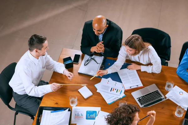 Formazione di nuovi dipendenti. Veduta aerea dei giovani multietnici che parlano, lavorano con colleghi, colleghi di lavoro in ufficio, in casa. Lavoro, finanza, tecnologia. — Foto Stock