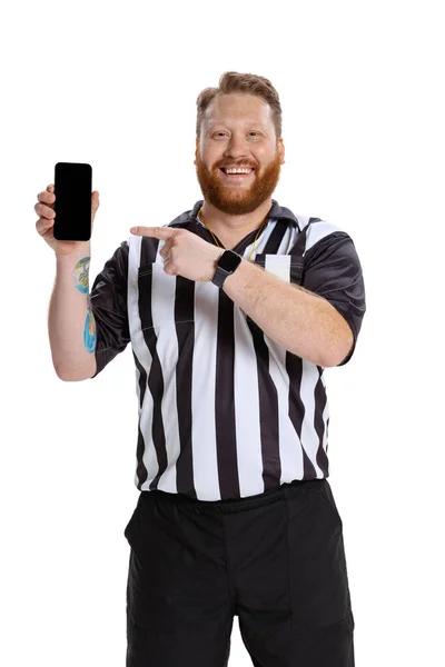 Portrait of young bearded man, soccer or football referee using phone isolated on white studio background. Concept of sport, rules, competitions, rights, ad, sales. — Stock Photo, Image