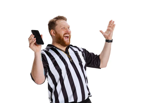 Retrato de jovem barbudo, futebol ou árbitro de futebol usando telefone isolado no fundo do estúdio branco. Conceito de esporte, regras, competições, direitos, anúncio, vendas. — Fotografia de Stock