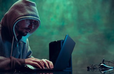 İnsan portresi, profesyonel programcı, güvenlik sistemini kıran web korsanı, neon içinde koyu yeşil arkaplan üzerinden izole edilmiş bilgiler indiriyor.