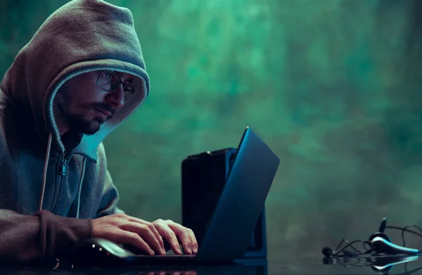 Портрет людини, професійний програміст, веб- хакер, що ламає систему безпеки, завантаження інформації ізольовано на темно-зеленому тлі в неоні — стокове фото
