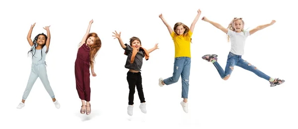 Cinque scolari o alunni che saltano in abiti casual colorati isolati su sfondo bianco. Collage creativo. — Foto Stock