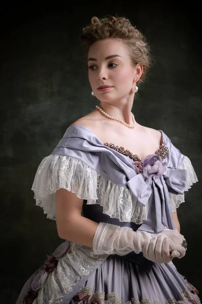 Vintage portret młodej uroczej dziewczyny w wizerunku średniowiecznej osoby królewskiej w stylu renesansowym sukienka izolowana na ciemnym tle. Porównanie epok — Zdjęcie stockowe