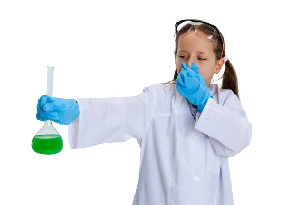 Retrato de niña de la escuela, niño en vestido grande blanco como químico, científico haciendo experimento con fluido químico multicolor en laboratorio aislado sobre fondo blanco — Foto de Stock