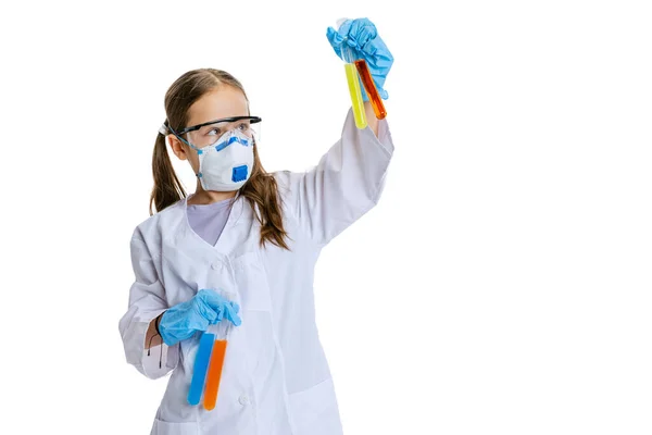 Researcher. One school girl, kid in white big gown as chemist, scientist doing experiment with multicolored chemical fluid in laboratory isolated on white background — Stock Photo, Image