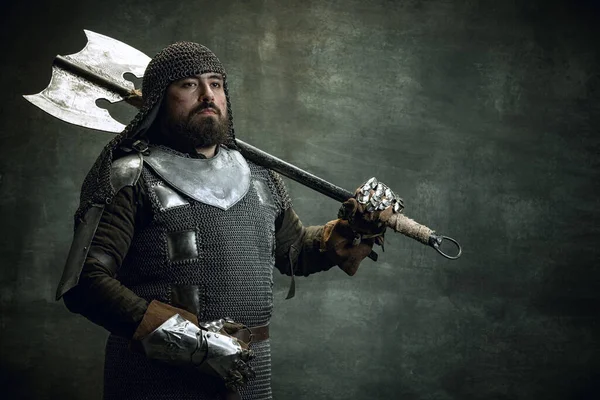暗い背景に隔離された斧を保持チェーンメールで負傷した顔を持つ残酷なシリアル男、中世の戦士や騎士のヴィンテージ肖像画。時代の比較 — ストック写真