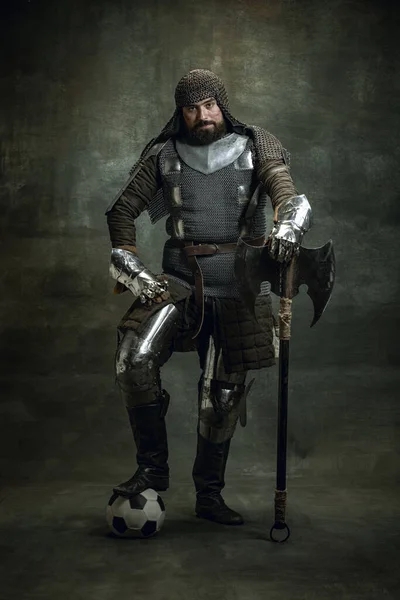 Acımasız bir adamın klasik portresi, Ortaçağ savaşçısı ya da zırhlı yaralı yüzlü şövalye karanlık arka planda izole edilmiş balta tutuyor. Dönem Karşılaştırması — Stok fotoğraf