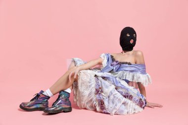 Rönesans tarzı elbise ve pembe arka planda izole edilmiş siyah kar maskeli ortaçağ kraliyet mensubu bir genç kızın komik portresi. Dönem karşılaştırması, güzellik